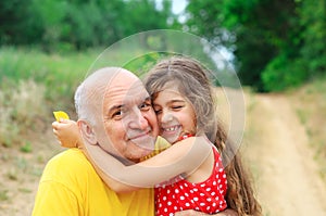 Portrait of granddad and granddaughter smiling at the park photo