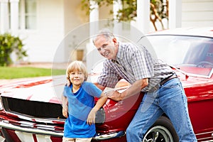 Portrait Of Grandfather And Grandson With Restored Car