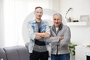 Portrait of grandfather and his teen grandson smiling. Isolated white background