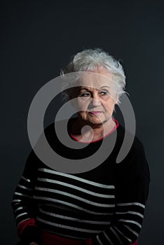 portrait of a grandmother in a dark sweater on a dark background