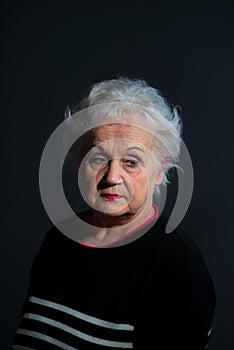 portrait of a grandmother in a dark sweater on a dark background