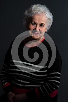 portrait of a grandmother in a dark sweater on a dark background