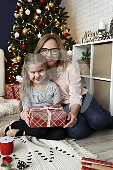 Portrait of grandmother and granddaughter embracing during the Christmas holidays