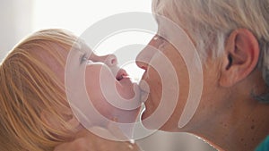 Portrait of grandmother and granddaughter. Grandma kissing her granddaughter