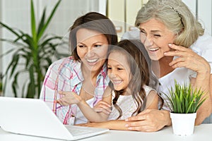 Portrait of a grandmother, mother and daughter using laptop