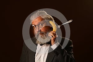 Portrait of a gray-haired elderly gentleman, with a shaggy mustache and beard, in a white shirt and gray jacket, wearing glasses