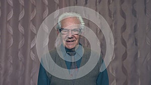 Portrait of a gray-haired grandfather with glasses on a pink background.