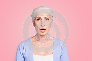 Portrait of grey haired old nice beautiful amazed shocked woman. Isolated over violet purple background