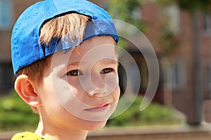 Portrait of a grinning boy wearing blue baseball cap