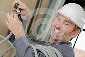 portrait grinning man poised to cut through electric cable