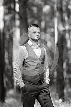 portrait of the groom in a gray suit and an orange vest