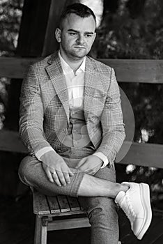 portrait of the groom in a gray suit and an orange vest