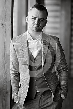 portrait of the groom in a gray suit and an orange vest