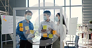 Portrait group of asian in medical mask in a diverse team of creative millennial coworkers