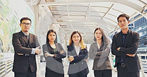 Portrait Group of businesspeople arms crossed smiling look at camera in modern city background. Happy Businessman, businesswoman