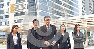 Portrait Group of businesspeople arms crossed smiling look at camera in modern city background. Happy Businessman, businesswoman