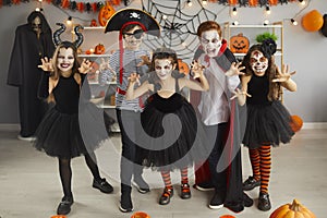 Portrait of group of children in creative costumes with scared faces at Halloween party.