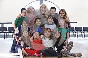 Portrait Of Group Of Children With Teacher Enjoying Drama Workshop Together