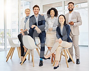 Portrait of a group of confident diverse businesspeople posing together in an office. Happy smiling colleagues motivated