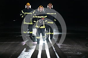 Portrait of a group of firefighters standing and walking brave and optimistic with a female as team leader.