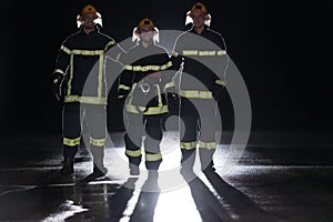 Portrait of a group of firefighters standing and walking brave and optimistic with a female as team leader.