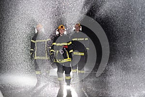 Portrait of a group of firefighters standing and walking brave and optimistic with a female as team leader.