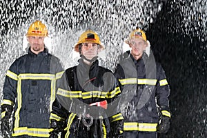 Portrait of a group of firefighters standing and walking brave and optimistic with a female as team leader.