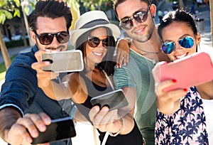 Portrait of group friends taking photos with a smartphone.