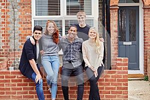 Portrait Of Group Of Smiling College Students Outside Rented Shared House photo