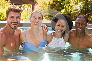 Portrait Of Group Of Smiling Multi-Cultural Friends On Holiday In Swimming Pool 