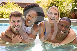 Portrait Of Group Of Smiling Multi-Cultural Friends On Holiday In Swimming Pool 