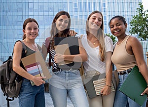 Portrait of a group of teenage student girls looking at camera smiling on a campus. Happy students at the high school