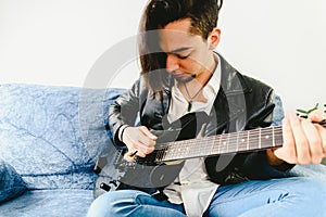 Portrait of guitarist with white shirt and expressive gesture of enjoyment of the music he is playing