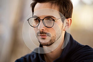 Portrait of a guy with glasses posing outdoors