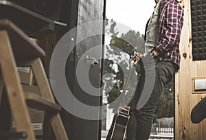 Portrait of a guy with a guitar. Musician guitarist in studio