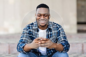 Portrait of guy listening to music and using phone