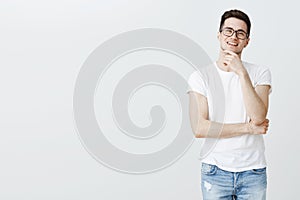 Portrait of guy pleased and delighted with great result of work rubbing chin smiling self-satisfied and joyful, having