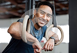 Portrait, gymnastic rings and olympics with a man gymnast hanging on equipment for workout in gym. Face, fitness and