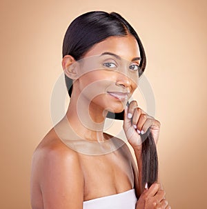 Portrait, hair care and Indian woman, with beauty, cosmetics and dermatology against a brown studio background. Face