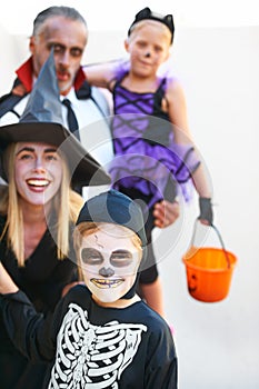 Portrait, halloween and a family in costume for the tradition of trick or treat or holiday celebration. Mother, father