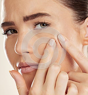 Portrait, hands and pimple with a woman checking or examining her skin for acne problems in studio. Face, fingers and