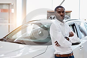 Portrait of handsome african man in car dealership