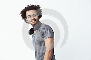 Portrait of handsome african man with headphones over white background. Copy space.