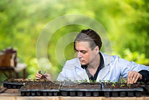 Portrait of handsome agricultural researcher working on research at plantation in industrial greenhouse