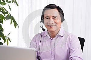 Portrait of handsome asian hotline person consultant wearing headset