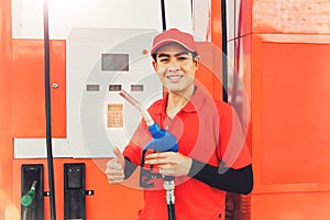 The portrait of a handsome Asian male worker enjoying the duty of refueling customers at the gas station is a great service thumbs