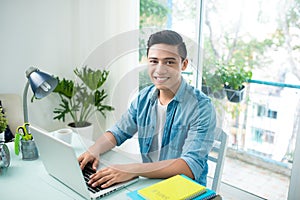 Portrait of handsome asian young business man working on laptop