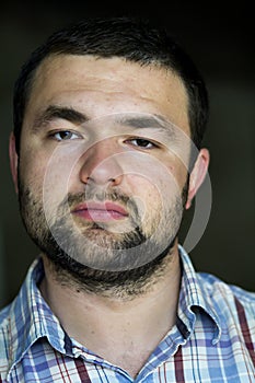 Portrait of handsome bearded confident intelligent modern photogenic young man with short haircut and kind black eyes looking thou