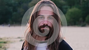 Portrait of handsome bearded young man with long hair