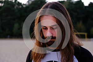 Portrait of handsome bearded young man with long hair